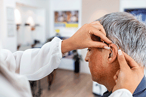 Man getting hearing aid maintenance